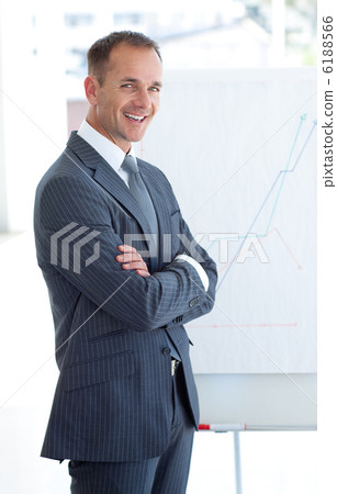 Mature businessman reporting to sales figures Mature businessman reporting to sales figures 6188566