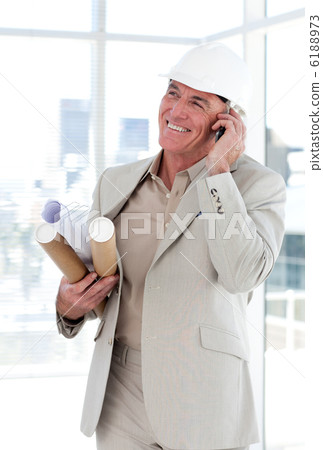 Senior architect on phone carrying blueprints Senior architect on phone carrying blueprints 6188973