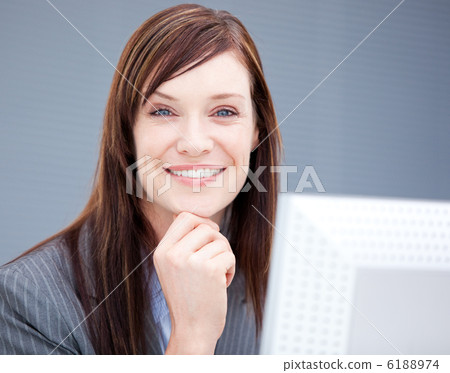 Cheerful businesswoman working at a computer 6188974