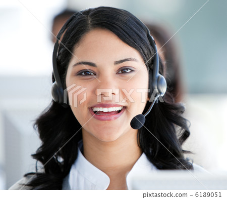 Beautiful businesswoman wearing a headset to talk with customer Beautiful businesswoman wearing a headset to talk with customer 6189051
