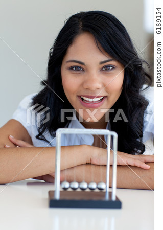 Businesswoman playing with Newton balls 6189154