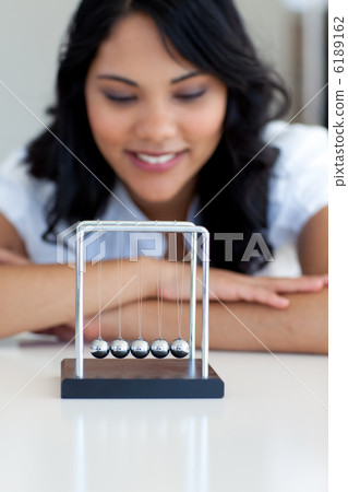 Businesswoman playing with kinetic balls 6189162