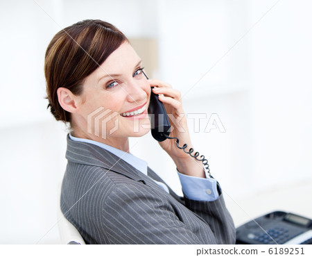 Confident businesswoman on phone sitting at her desk 6189251