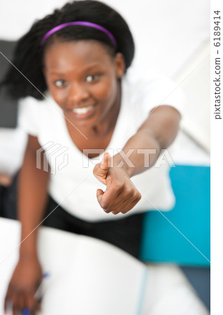 Cheerful teen girl with a thumb up studying Cheerful teen girl with a thumb up studying 6189414