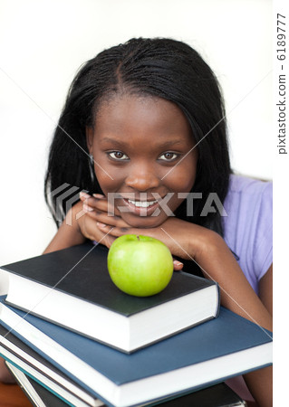 Young student holding books smiling at the camera Young student holding books smiling at the camera 6189777