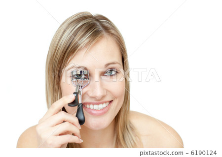 Smiling woman using an eyelash curler Smiling woman using an eyelash curler 6190124