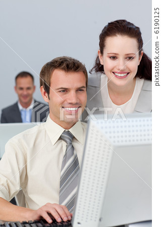Smiling business partners working together at a computer Smiling business partners working together at a computer 6190125