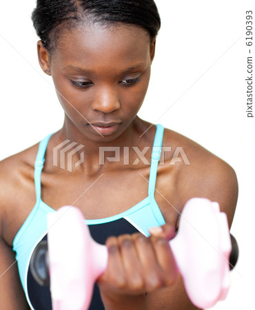 Serious woman working out with dumbbell Serious woman working out with dumbbell 6190393
