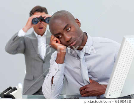 Afro-american businessman annoyed by a man looking through binoc 6190488