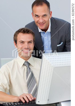 Assertive business partners working together at a computer Assertive business partners working together at a computer 6190572