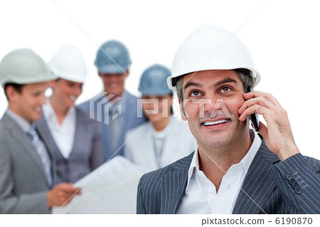 Confident male architect on phone in front of his team Confident male architect on phone in front of his team 6190870