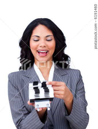 Enthusiastic businesswoman consulting a business card holder Enthusiastic businesswoman consulting a business card holder 6191460