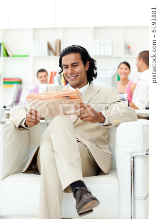 Smiling manager reading a newspaper 6191881