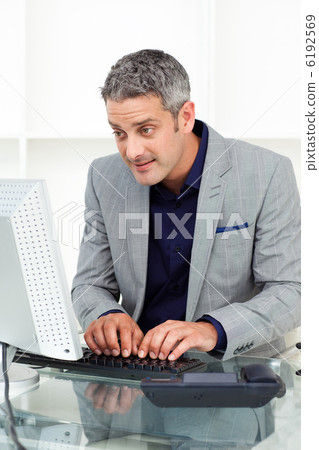 Concentrated businessman working at a computer 6192569