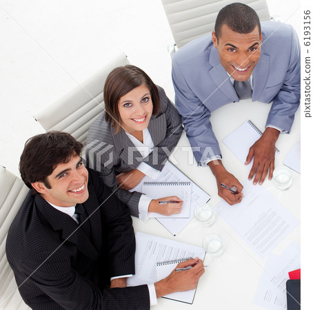 Three colleagues smiling at the camera in a meeting 6193156
