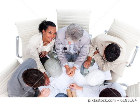Confident multi-ethnic architects studying blueprints 6193164