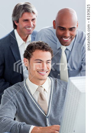 Smiling businessmen working at a computer 6193625