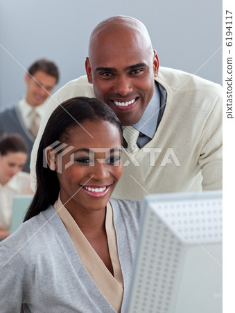 Portrait of two enthusiastic businesspeople working at a compute 6194117