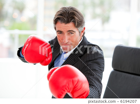 Competitive businessman wearing boxing gloves 6194207