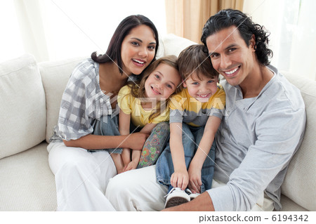 Joyful family sitting on sofa 6194342