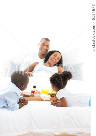 Cheerful family having breakfast in the bedroom 6194677
