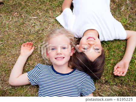 Adorable siblings lying on the grass Adorable siblings lying on the grass 6195225