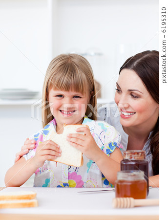 Happy little girl and her mother eating slices of bread Happy little girl and her mother eating slices of bread 6195310