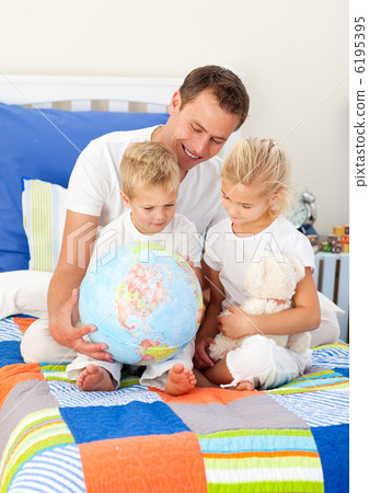 Blond siblings and their father looking at a terrestrial globe Blond siblings and their father looking at a terrestrial globe 6195395