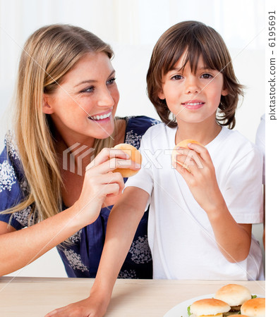 Attractive mother and her son eating burgers 6195691