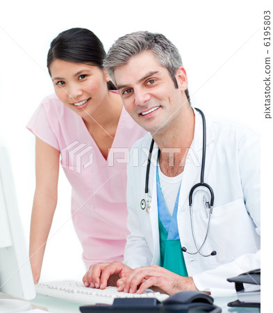 Smiling doctor and nurse working at computer Smiling doctor and nurse working at computer 6195803