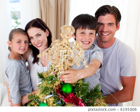 Portrait of a family decorating a Christmas tree Portrait of a family decorating a Christmas tree 6195806