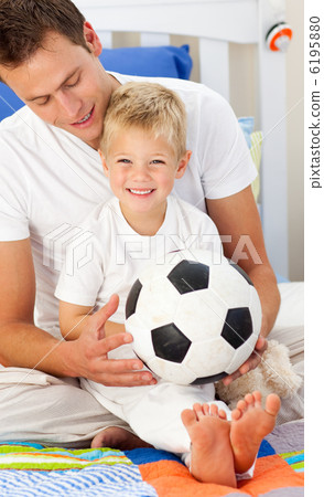 Smiling little boy and his father playing with a soccer ball Smiling little boy and his father playing with a soccer ball 6195880