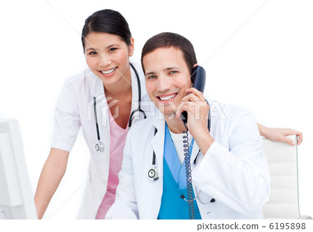 Charming doctor and his colleague on phone Charming doctor and his colleague on phone 6195898