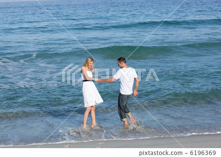 Joyful lovers having fun at the seaside 6196369
