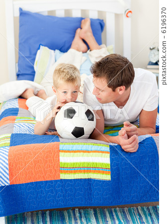 Adorable little boy and his father watching a football match Adorable little boy and his father watching a football match 6196370