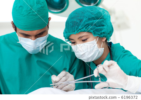 Portrait of two ethnic surgeons in operative room 6196372