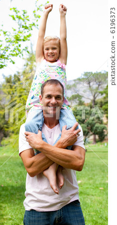 Joyful father giving his daughter piggy-back ride Joyful father giving his daughter piggy-back ride 6196373
