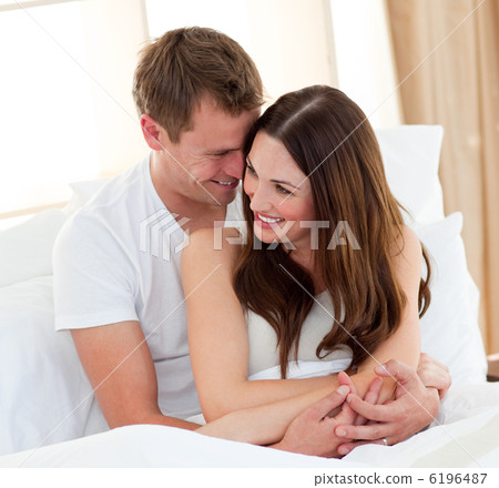 Romantic lovers embracing lying in bed Romantic lovers embracing lying in bed 6196487