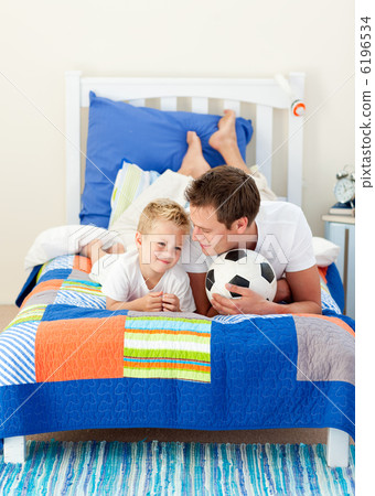 Attractive father and his son playing with a soccer ball Attractive father and his son playing with a soccer ball 6196534