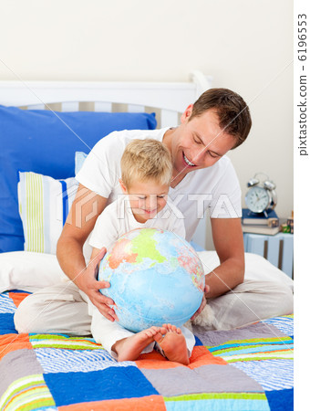 Laughing father and his son looking at a terrestrial globe Laughing father and his son looking at a terrestrial globe 6196553