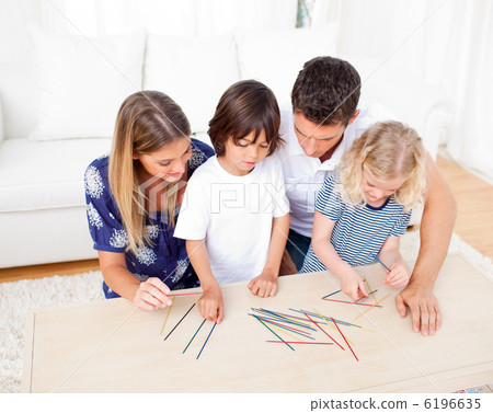 Loving family playing mikado in the living room Loving family playing mikado in the living room 6196635