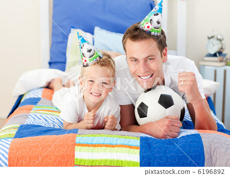 Cute little boy and his father watching a football match 6196892