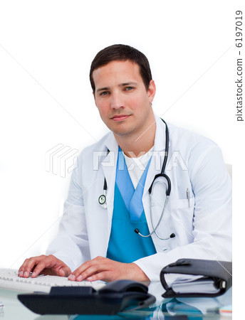 Charming male doctor working at a computer 6197019