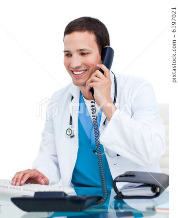 Young male doctor on phone working at a computer Young male doctor on phone working at a computer 6197021