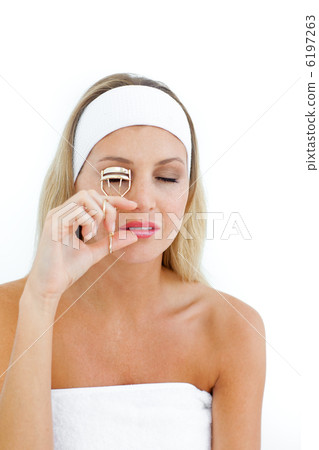 Young woman using an eyelash curler Young woman using an eyelash curler 6197263