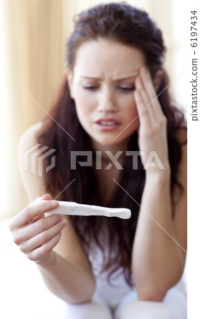 Woman looking at a pregnancy test 6197434