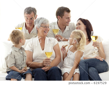 Family in living-room drinking wine and eating biscuits 6197529