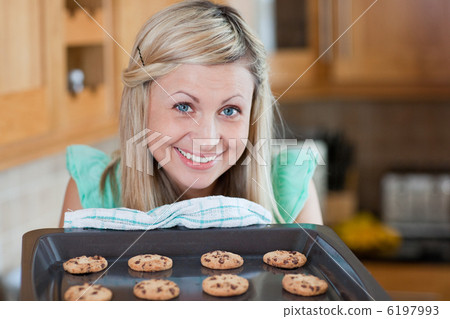 Cute young woman baking cookies Cute young woman baking cookies 6197993