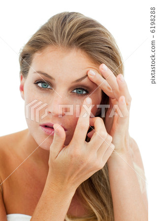 Concentrated woman putting a contact lens 6198288