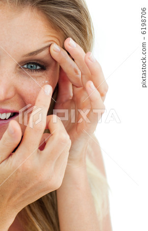 Charming woman putting a contact lens 6198706